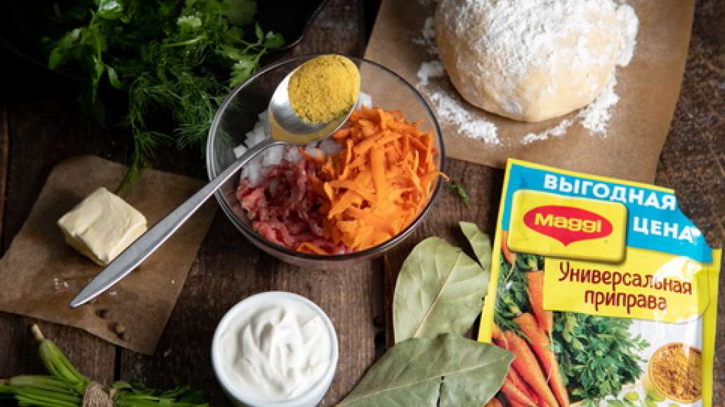 Вымесить  фарш с водой,  луком ,чесноком ,тертой морковью и  MAGGI® Универсальная приправа. Достать тесто из холодильника, присыпать мукой стол или раскаточную доску.