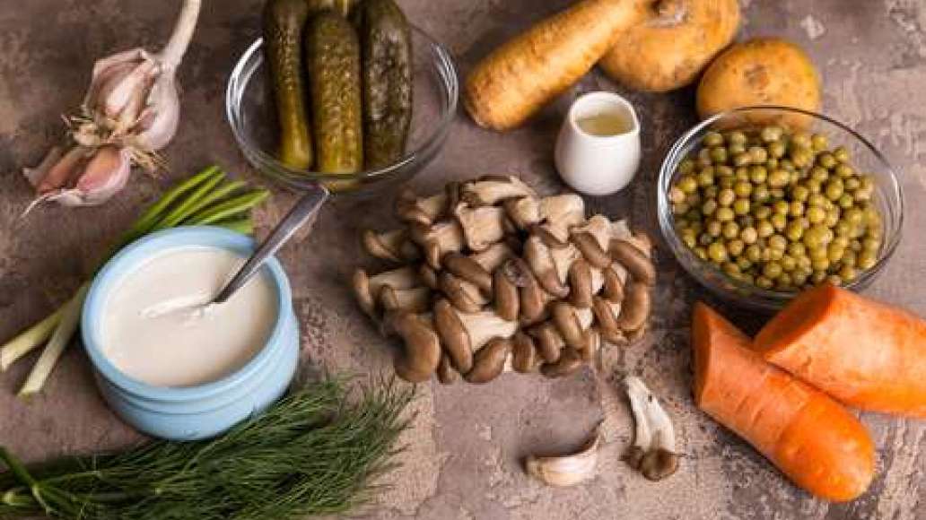 Болгарский перец нарезать кубиками. Слить жидкость из банки с зеленым горошком.