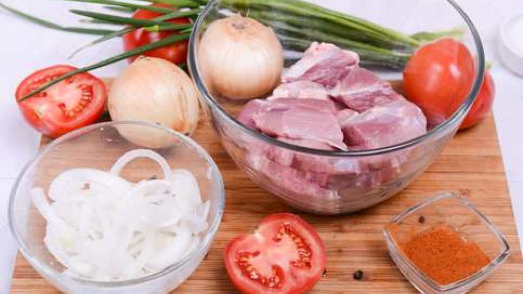 Нарежьте мясо на кусочки 4-5 см, переложите в большую миску или кастрюлю. Лук нарежьте полукольцами, добавьте соль и помните смесь руками. Переложите в отдельную миску.