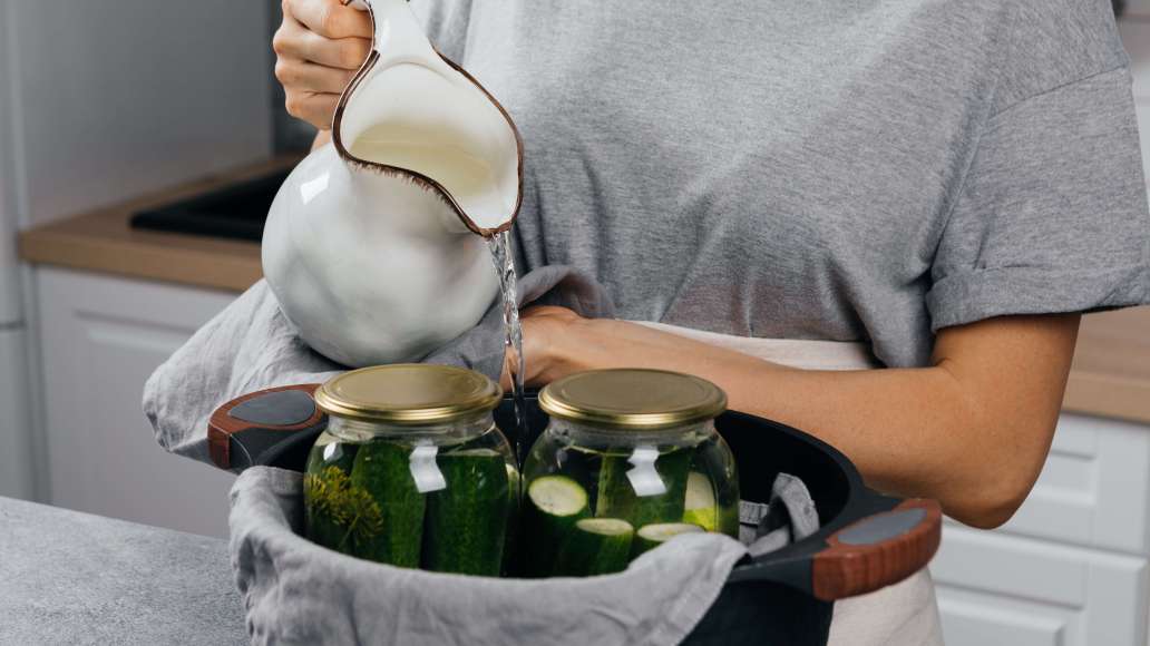 На дно большой кастрюли выложить кухонное полотенце. Поставить в кастрюлю банки с огурцами. Влить горячую воду по «плечики» банок (не использовать кипяток, так как банки могут лопнуть). На дно большой кастрюли выложить кухонное полотенце. Поставить в кастрюлю банки с огурцами. Влить горячую воду по «плечики» банок (не использовать кипяток, так как банки могут лопнуть).