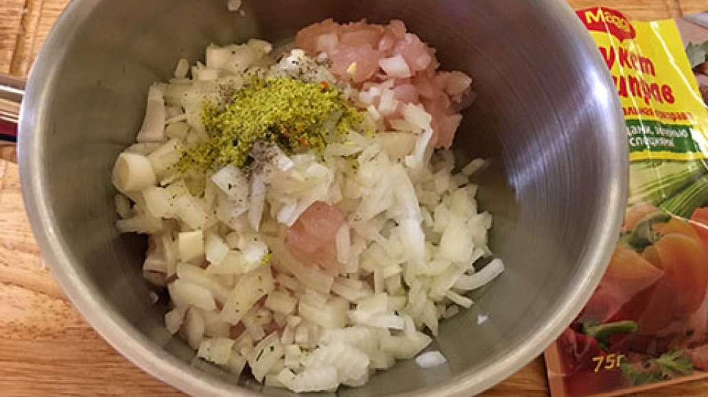 В миску выложить мясо, добавить лук, приправить Магги и поперчить.
