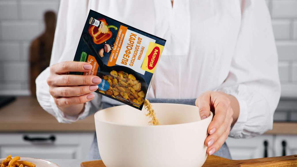 Добавить 4 ст. л. растительного масла, MAGGI® Приправу для золотистого картофеля и тщательно перемешать.