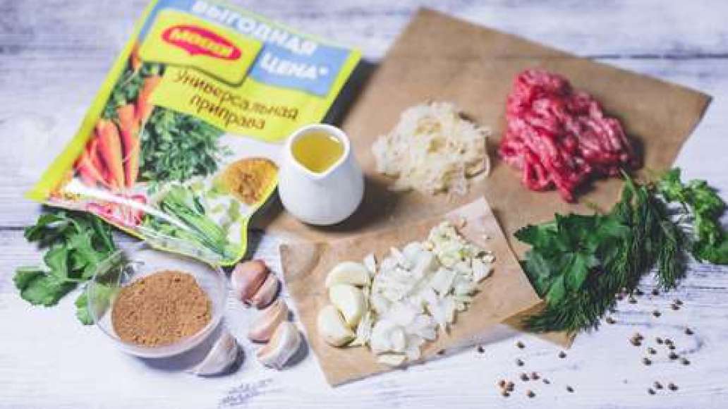 Мелко измельчить фарш вручную (или через мясорубку с крупной ячейкой), с луком и чесноком. Добавить специи MAGGI® Универсальная приправа. Почистить и натереть картофель на терке. Затем посолить картофель и вмешать его в фарш. Зелень отобрать от стеблей и 