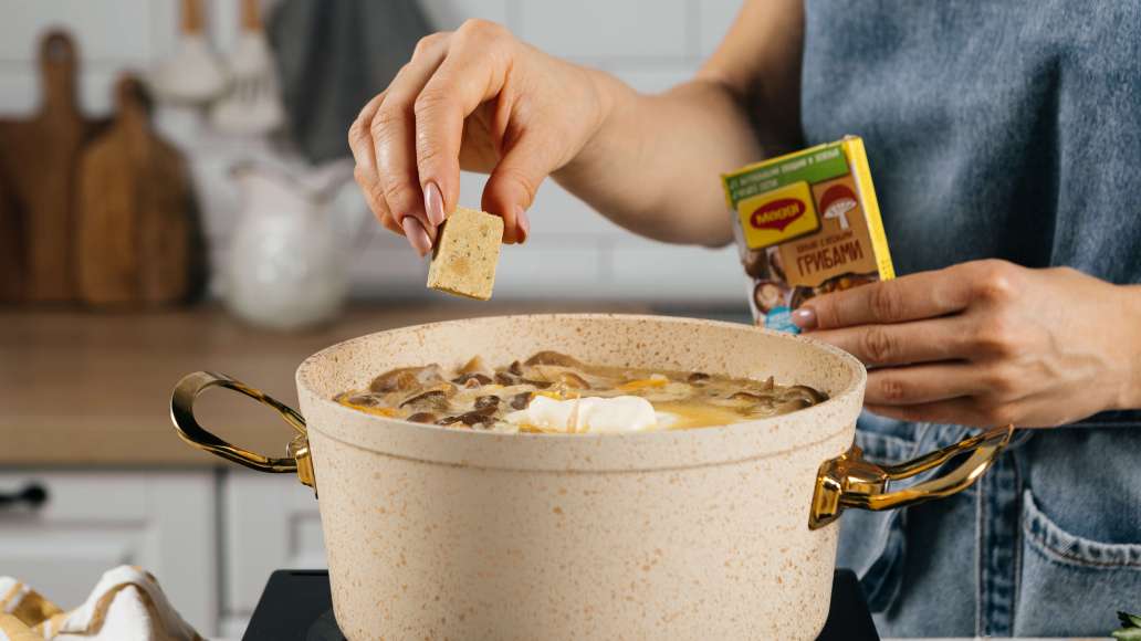 Натереть сыр на мелкой терке. Добавить сыр в суп. Добавить кубики MAGGI® Бульон с лесными грибами. Перемешать и готовить еще 5 минут на среднем огне.