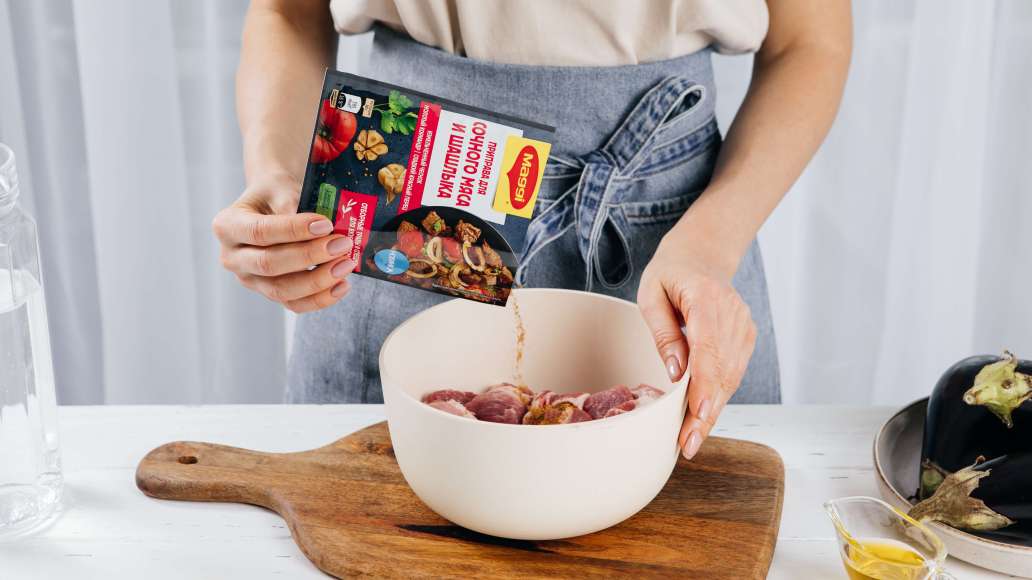 Переложить мясо в стеклянную или эмалированную емкость. Добавить MAGGI® Приправу для сочного мяса и шашлыка. Как следует перемешать, втирая приправу в мясо.